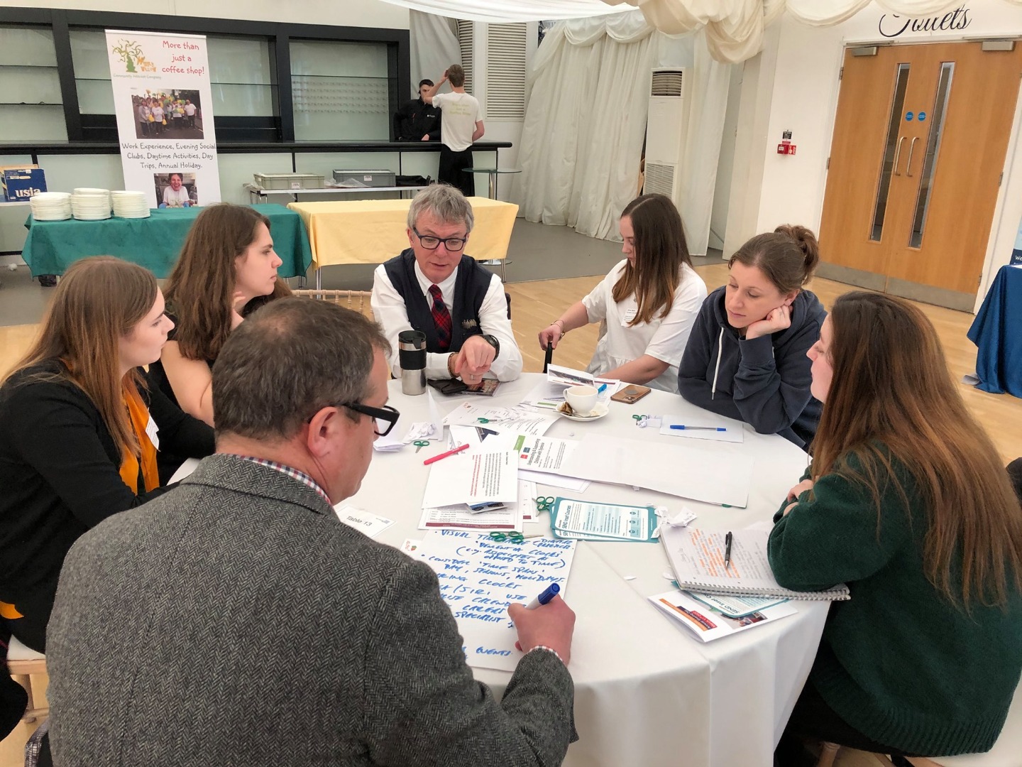 a group of people sat round table having a discussion